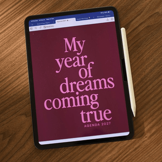 Portada My year of dreams coming true de la Agenda 2027 en iPad sobre mesa de madera