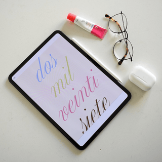 Agenda 2027 en iPad con la portada dos mil veintisiete junto a lentes y audífonos